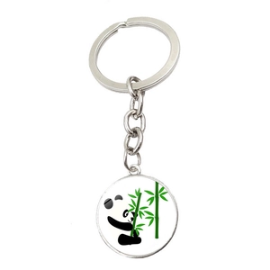 Detail of silver metal keychain with a round pendant featuring a panda holding bamboo