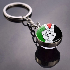 Palestine flag glass dome keychain with peace sign graphic on black reflective background