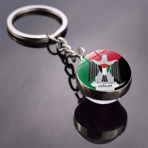 Close-up of Palestine flag emblem keychain with glass cabochon on a reflective surface