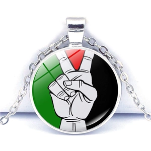 Vista macro di una collana con ciondolo bandiera palestinese con cupola in vetro e base in metallo