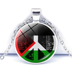 Dettaglio macro del ciondolo d'argento con bandiera palestinese e simbolo della pace