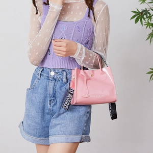 Mini sac seau rose brillant avec texte Little Beauty et large bandoulière sur mannequin