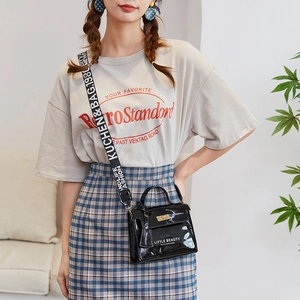 Glossy black patent leather crossbody bag with letter print strap and metal buckle
