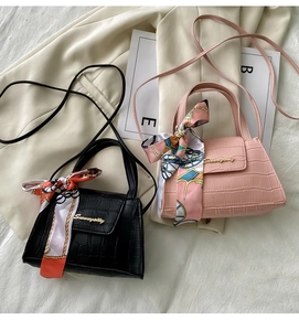 Detail of mini crocodile pattern handbags with silk scarf handle and gold metal logo