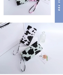 Detailed view of long cow print wallets with zipper closure and matching wrist strap
