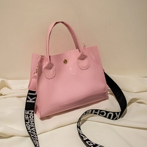 Sac seau rose brillant en cuir verni avec large bandoulière tissée et boucle métallique