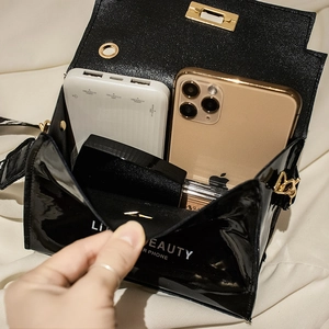 Glossy black patent leather mini crossbody bag with gold lock and interior phone storage