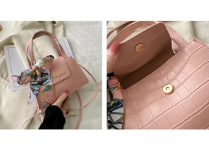 Close-up of pink faux leather crocodile pattern texture and magnetic snap closure