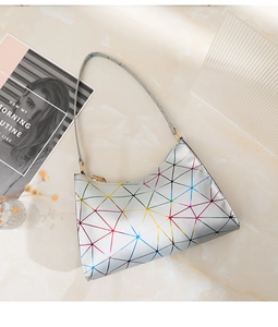 Details von irisierenden geometrischen Dreiecken auf silberner Schultertasche mit Goldakzenten
