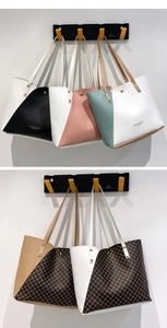 Multiple color variations of stitched leather tote bags hanging on wall hooks