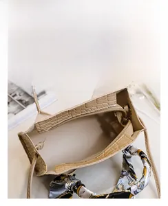 Innenansicht der Kroko-Handtasche mit Reißverschlussfach und dekorativem Seidenschal