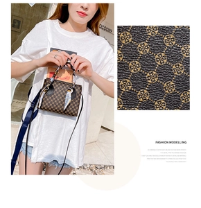 Detailed view of brown monogram handbag featuring decorative silk scarf and textured leather