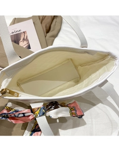 Top view of white quilted tote bag interior with silk scarf and zipper closure detail