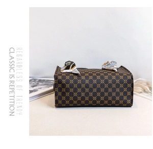 Detail view of printed tote bag with classic monogram pattern and decorative silk scarf