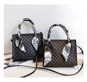 Detailed view of vintage monogram tote bags with decorative silk scarves and leather straps