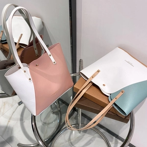 Women's color block tote bags in pink and blue with metal studs and top handles