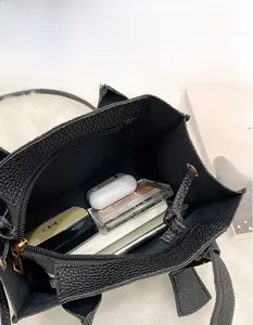 Top view of spacious interior of black pebble leather handbag showing daily essentials