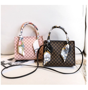 Detail of vintage patterned handbags with decorative silk scarves on warm sofa background
