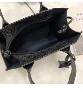 Detailed top view of the black lychee pattern leather bag interior with knot detail