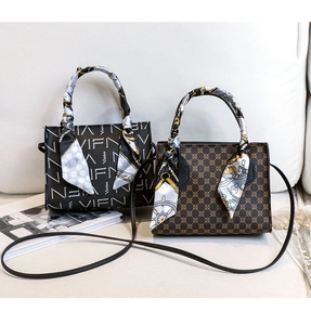 Close-up of printed handbags featuring silk scarves and vintage patterns on a white sofa