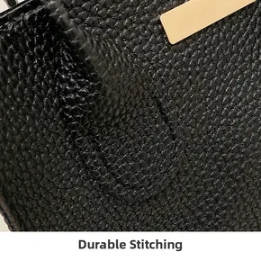 Close-up of black lychee grain leather handbag featuring precision tight stitching and gold metal