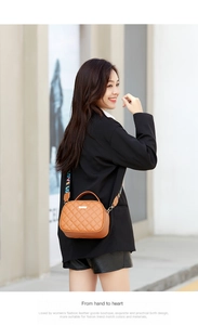 Detail of a brown quilted crossbody bag with a colorful 'LOVE' embroidered strap on a model