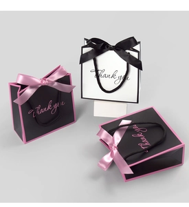 Mini gift bags with black bow and pink accents featuring Thank You text for packaging