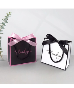 Detail of elegant gift bags with satin bows and Thank You text for party favors