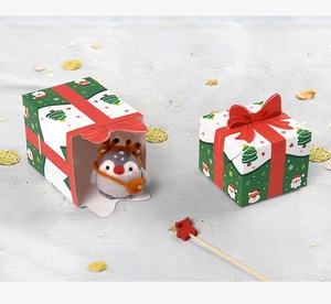 Detail of Christmas candy boxes with red bows and a cute penguin plush inside