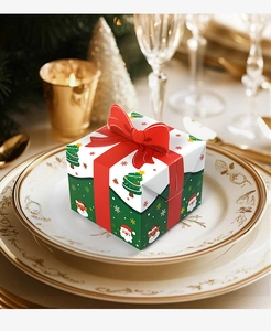 Mini Christmas gift box with red bow and festive patterns on a ceramic plate detail
