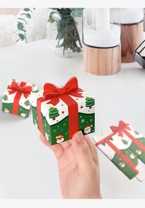 Detail of mini Christmas gift box with red bow and festive holiday patterns