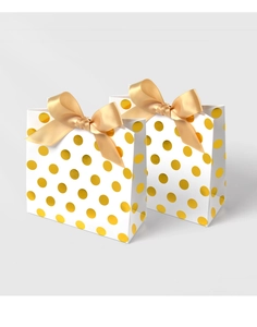 Detailed view of white gift bags with gold polka dots and elegant satin bows