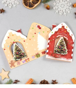 Nahaufnahme von 3D-Weihnachtskarten in Hausform mit Merry Christmas-Schriftzug und Motiven