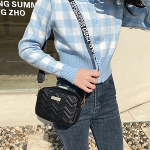 Chic black V-quilted crossbody camera bag featuring a wide graphic lettered shoulder strap