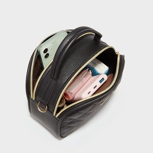 Black quilted crossbody bag with dual zipper compartments showing spacious storage