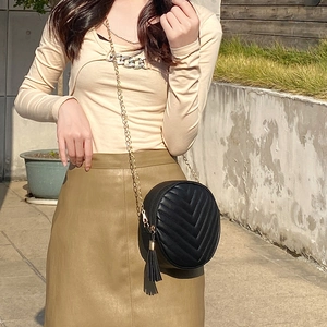 Black round quilted crossbody bag with stylish tassel and gold chain strap
