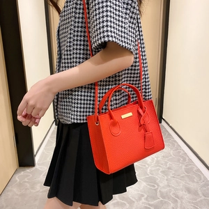 Red lychee pattern mini tote bag with gold hardware and top handles shown on model