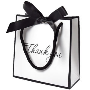 Minimalist white gift bag with black trim, satin bow, and Thank You lettering