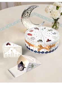 Detail of Eid Mubarak triangle favor boxes forming a cake shape with gold ribbon ties