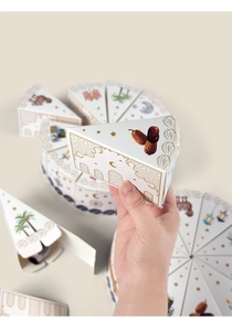 Detail of white triangular cake-shaped gift boxes with golden Ramadan pattern illustrations