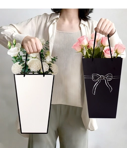 Trapezoid gift bag with handle showing floral arrangement and black bow design