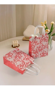 Detail of coral red and white vintage embossed gift bags with ribbon handles and bows