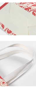 Detail of red floral patterns on gift bag with flat handles and reinforced base
