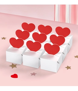 Detailed view of nine mini white gift boxes with 3D red heart inserts on a pink background