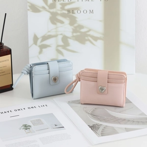 Close-up of minimalist short PU leather wallets with heart buckle in pink and light blue