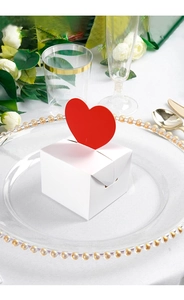Close-up of a white Valentine gift box with a 3D red heart card on a decorative plate