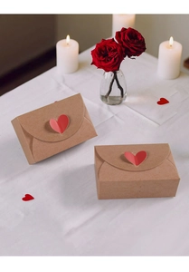 Kraft paper envelope gift box with a red heart-shaped clasp on a romantic table setting