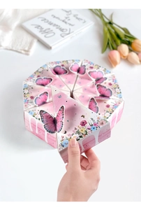 Close-up of pink butterfly triangle cake gift boxes with floral prints for parties
