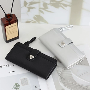 Detail of long PU leather wallets with heart buckle and wristlet in black and silver