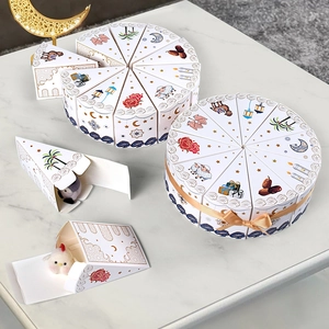 Triangle cake shaped white Eid gift boxes with gold ribbon and cultural moon patterns